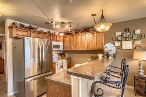a kitchen with a stainless steel refrigerator and wooden cabinets at WW D302 Chateau Relaxeau in New Braunfels +18 photos
