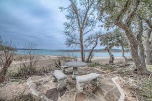 a picnic table and two benches next to the beach at CL 874 Million Dollar View in Canyon Lake