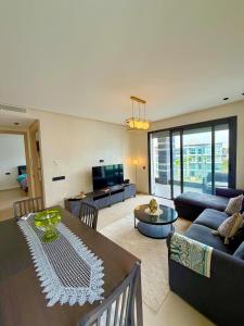 a living room with a table and a couch at Beachfront luxury 2 bedroom appartement with pool and gym in Mansouria