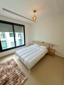 a bedroom with a large bed and a large window at Beachfront luxury 2 bedroom appartement with pool and gym in Mansouria +26 photos