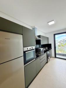 a kitchen with stainless steel appliances and a large window at Beachfront luxury 2 bedroom appartement with pool and gym in Mansouria