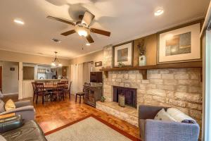 a living room with a stone fireplace and a ceiling fan at CW C113 Comal Vista in New Braunfels
