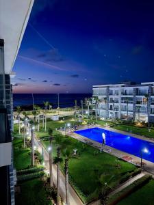 a resort with a swimming pool at night at Beachfront luxury 2 bedroom appartement with pool and gym in Mansouria