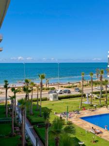 a view of the beach and the ocean from a resort at Beachfront luxury 2 bedroom appartement with pool and gym in Mansouria