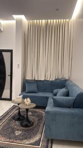 a blue couch in a living room with a table at وحده نجمة الفندقيه2 in Al Qurayyat
