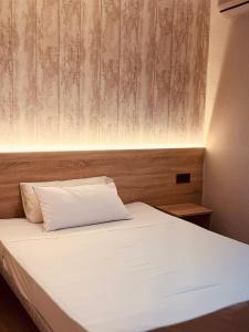 a bed with a white pillow in a room at Hotel Alain by Dynamic Hotels in Silla