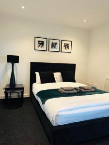 a bedroom with a large bed with a black headboard at Cozy 1 bed city apartment in Peterborough +6 photos