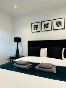a bedroom with a bed with towels on it at Cozy 1 bed city apartment in Peterborough