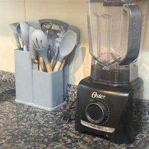 a blender on a counter with a container of utensils at Maryah Prime Studio Hotel Extrema + breakfast in Extrema