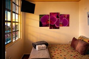 a room with three paintings of flowers on the wall at Villa Jair Hotel in Filandia