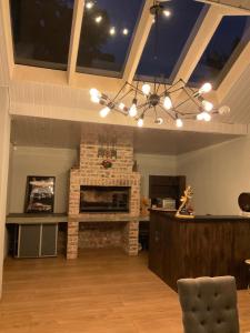 a living room with a brick fireplace and a chandelier at Almond Place in Tokai