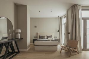 a bedroom with a bed and a desk and a chair at Suites 43 Juan Llorens in Valencia