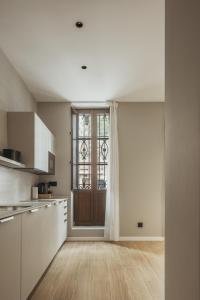 a kitchen with white cabinets and a large window at Suites 43 Juan Llorens in Valencia