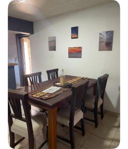 a dining room table with chairs and a table at Tres Raíces in Miramar