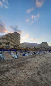 a beach with a bunch of chairs and buildings at 2BR Sea View Chalet Porto sokhna in Ain Sokhna
