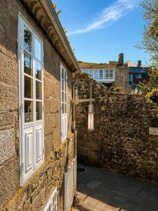 a brick building with a window and a stone wall at Casa Bolumburu in Pontevedra