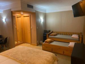 a hotel room with two beds and a television at Flat Guarulhos - 3 in Guarulhos +8 photos