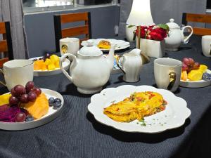 a table with plates of food and cups and fruit at Hostal New York in Jauja