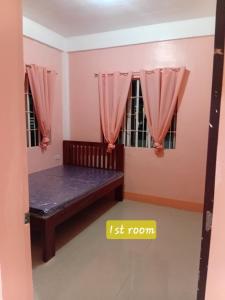 a room with a bed and two windows at Bato transient house in Bato