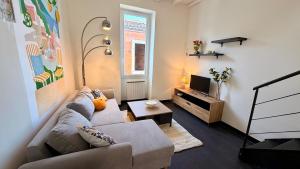 a living room with a couch and a tv at La Suite Limoncello, Sunny & Spacious in Nîmes