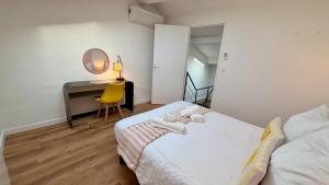 a bedroom with a bed and a desk with a mirror at La Suite Limoncello, Sunny & Spacious in Nîmes