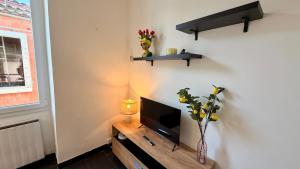 a living room with a television on a wooden table at La Suite Limoncello, Sunny & Spacious in Nîmes +23 photos