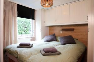 a bedroom with a bed with two pillows on it at Sfeervol Boschalet 5 persoons met Sauna in Voorthuizen