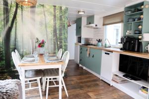 a kitchen with a table and chairs in a kitchen at Sfeervol Boschalet 5 persoons met Sauna in Voorthuizen