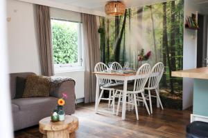 a living room with a couch and a table and chairs at Sfeervol Boschalet 5 persoons met Sauna in Voorthuizen +31 photos