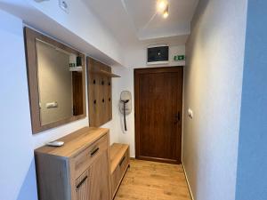 a bathroom with a wooden dresser and a mirror at Divine Apartmani in Dobanovci