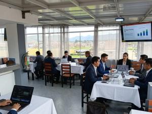a group of people sitting at tables with their laptops at Hostal New York in Jauja