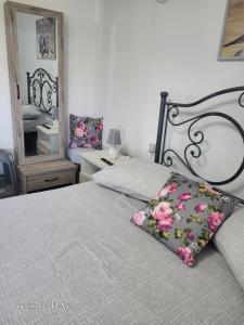 a bedroom with a bed with a pillow and a mirror at Estella in Naxos Chora