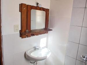 a white bathroom with a sink and a mirror at Pacha Wasi in Humahuaca +32 photos