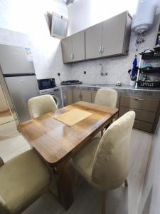 a kitchen with a wooden table and chairs at شقة مفروشة للكراء اكادير للعائلات فقط in Agadir