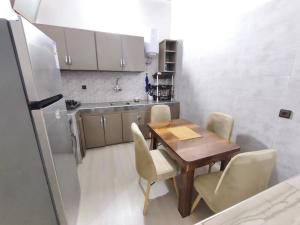 a small kitchen with a wooden table and chairs at شقة مفروشة للكراء اكادير للعائلات فقط in Agadir