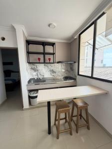a kitchen with a table and two stools at Hotel Yivinaca in Barranquilla
