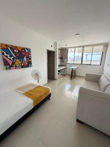 a bedroom with a bed and a couch and a table at Hotel Yivinaca in Barranquilla +46 photos
