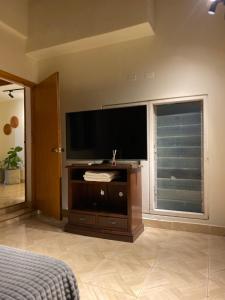 a bedroom with a flat screen tv and a large window at Estudio 201 Barrio blanco Estrato 5 in Cúcuta
