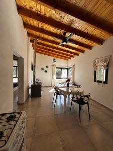 a kitchen and dining room with a table and a stove at La Pausa Córdoba, casa en Los Reartes in Los Reartes
