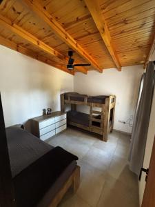 a bedroom with two bunk beds and a ceiling at La Pausa Córdoba, casa en Los Reartes in Los Reartes