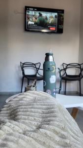 a bottle of water sitting on a table with a tv at La Pausa Córdoba, casa en Los Reartes in Los Reartes