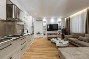 a kitchen and living room with a couch and a table at The Garden Jacuzzi Apartment By PS in Golem