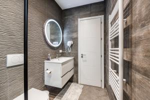 a bathroom with a sink and a mirror at The Garden Jacuzzi Apartment By PS in Golem +33 photos