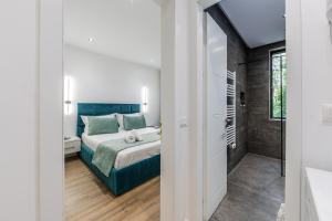 a bedroom with a bed and a walk in shower at The Garden Jacuzzi Apartment By PS in Golem