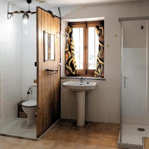 a bathroom with a sink and a toilet and a window at Casa La Farrapona Torrestío Babia in Torrestío