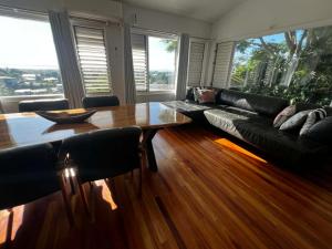 a living room with a black couch and a wooden table at 3BR Oceanview Villas - Raisara Retreat, Central Suva in Suva