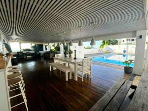 a dining room and living room with a table and a pool at 3BR Oceanview Villas - Raisara Retreat, Central Suva in Suva
