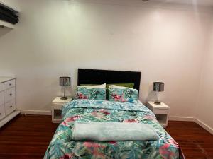 a bedroom with a bed with two night stands and two lamps at 3BR Oceanview Villas - Raisara Retreat, Central Suva in Suva