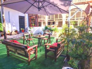 a patio with a table and chairs and an umbrella at KANTIQ House in Cusco
