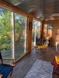 a screened in porch with windows and a chair at Dragonfly Cottage in Plymouth